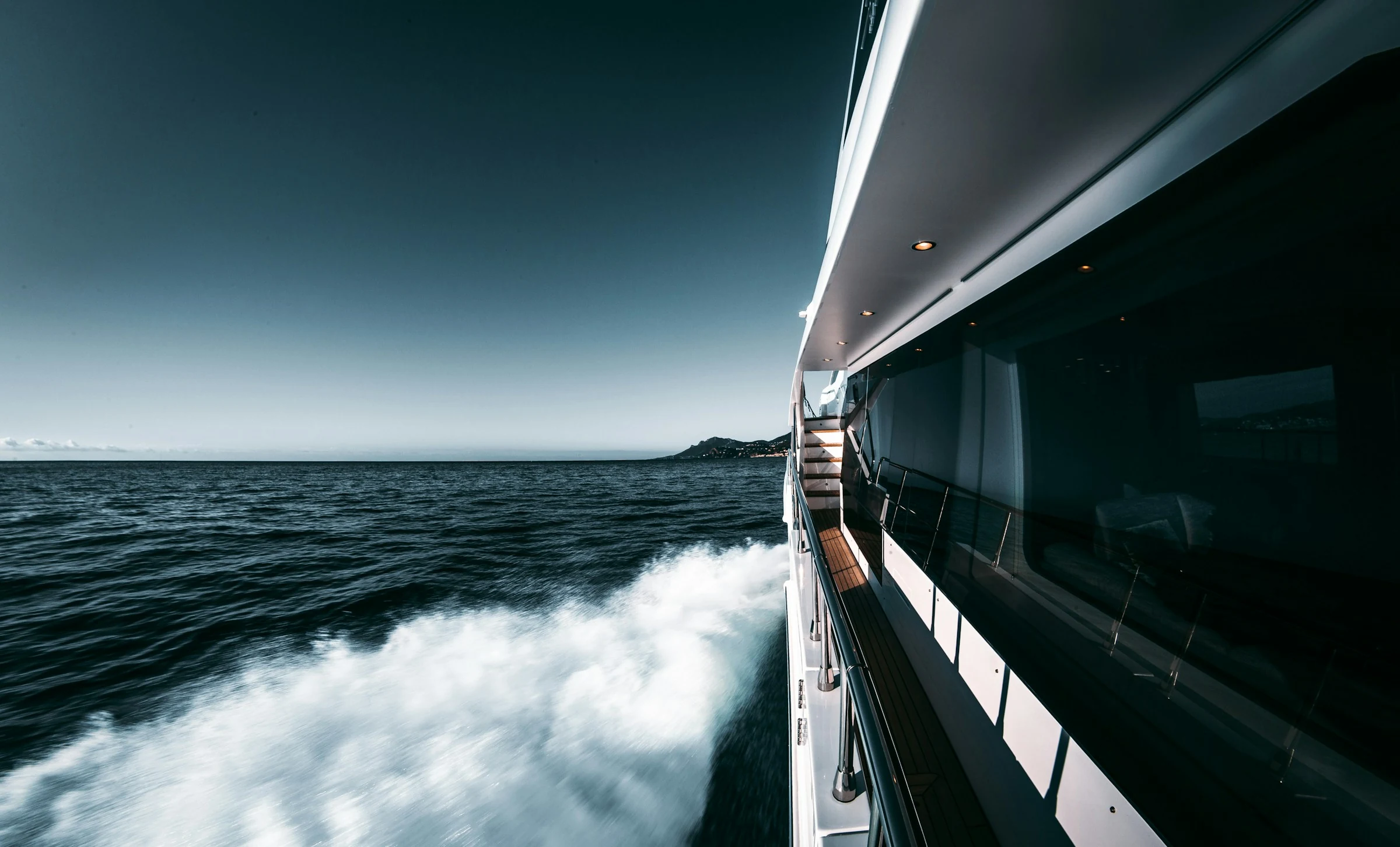 Yacht à moteur haut de gamme en navigation à Cannes, vue sur la coque et le sillage