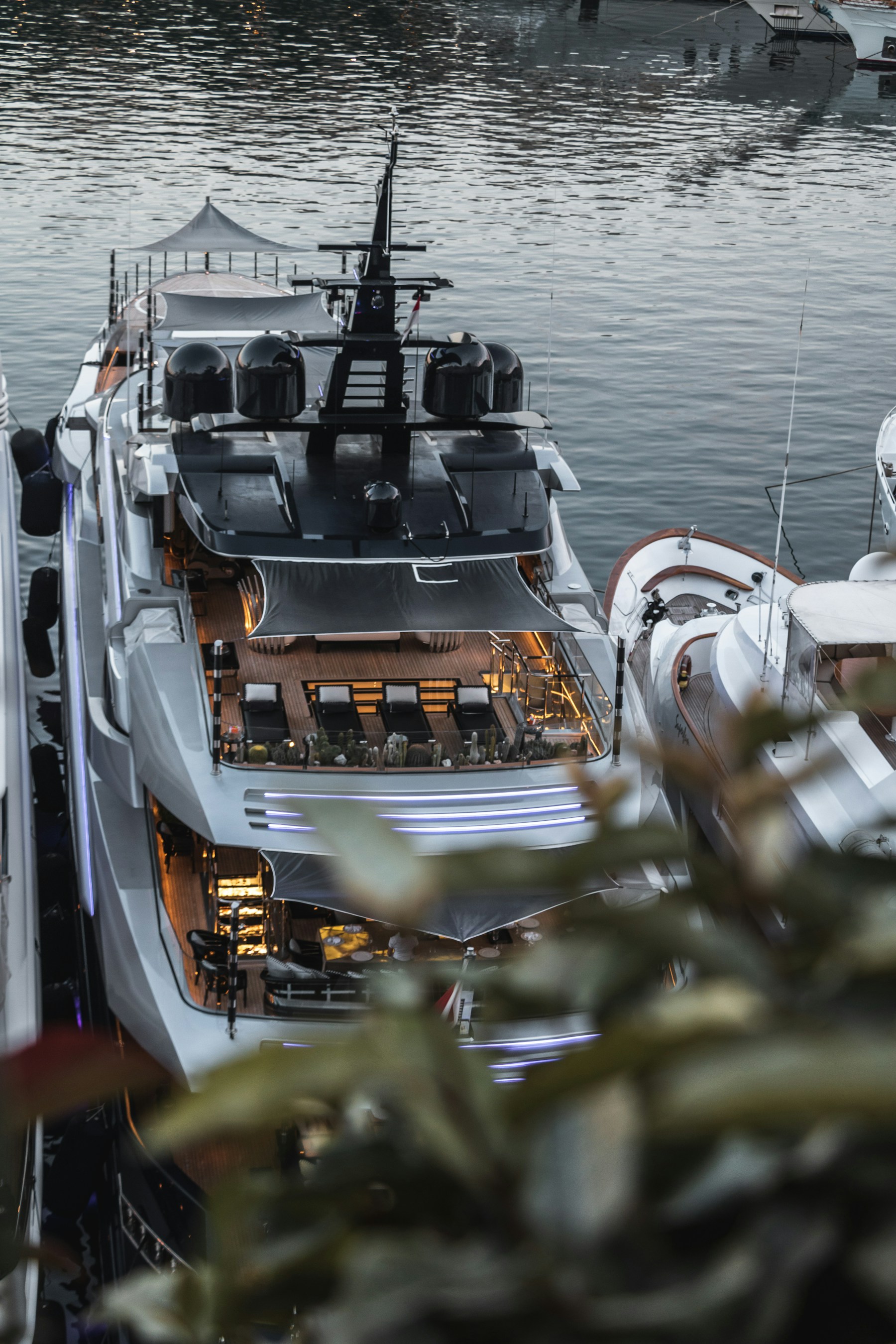 Yacht de luxe vu en hauteur, ponts blancs, vitrages sombres et éclairages de bord