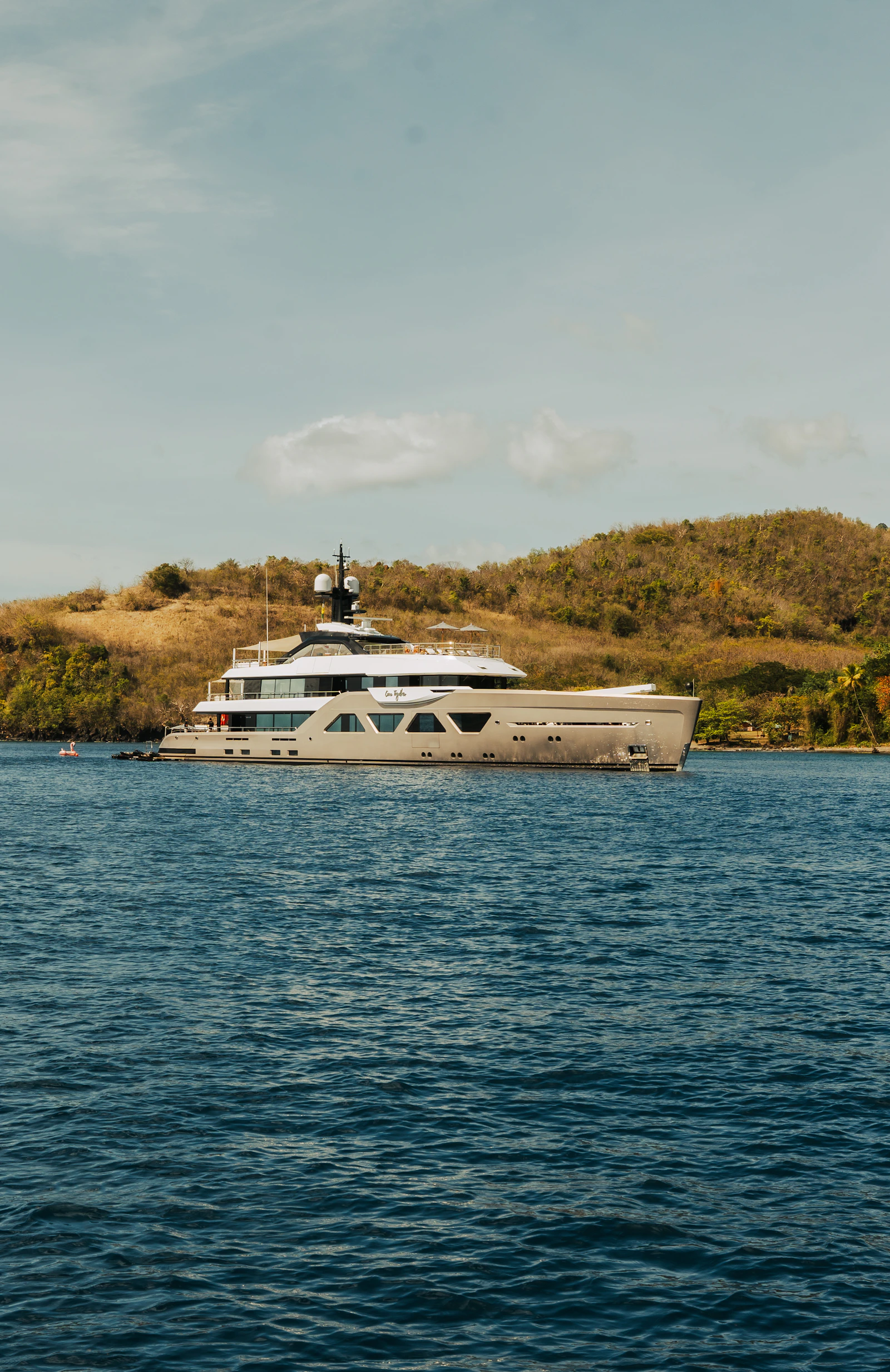 Yacht à moteur contemporain au mouillage, sur une mer bleu profond